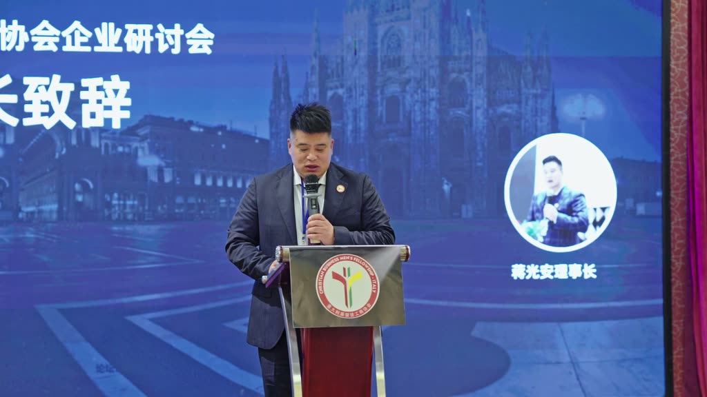 蒋光安理事长站在讲台后发言,讲台围裙上是本会会徽